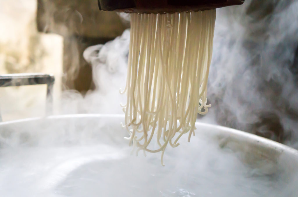 Traditional noodles making procedure on a vintage machine